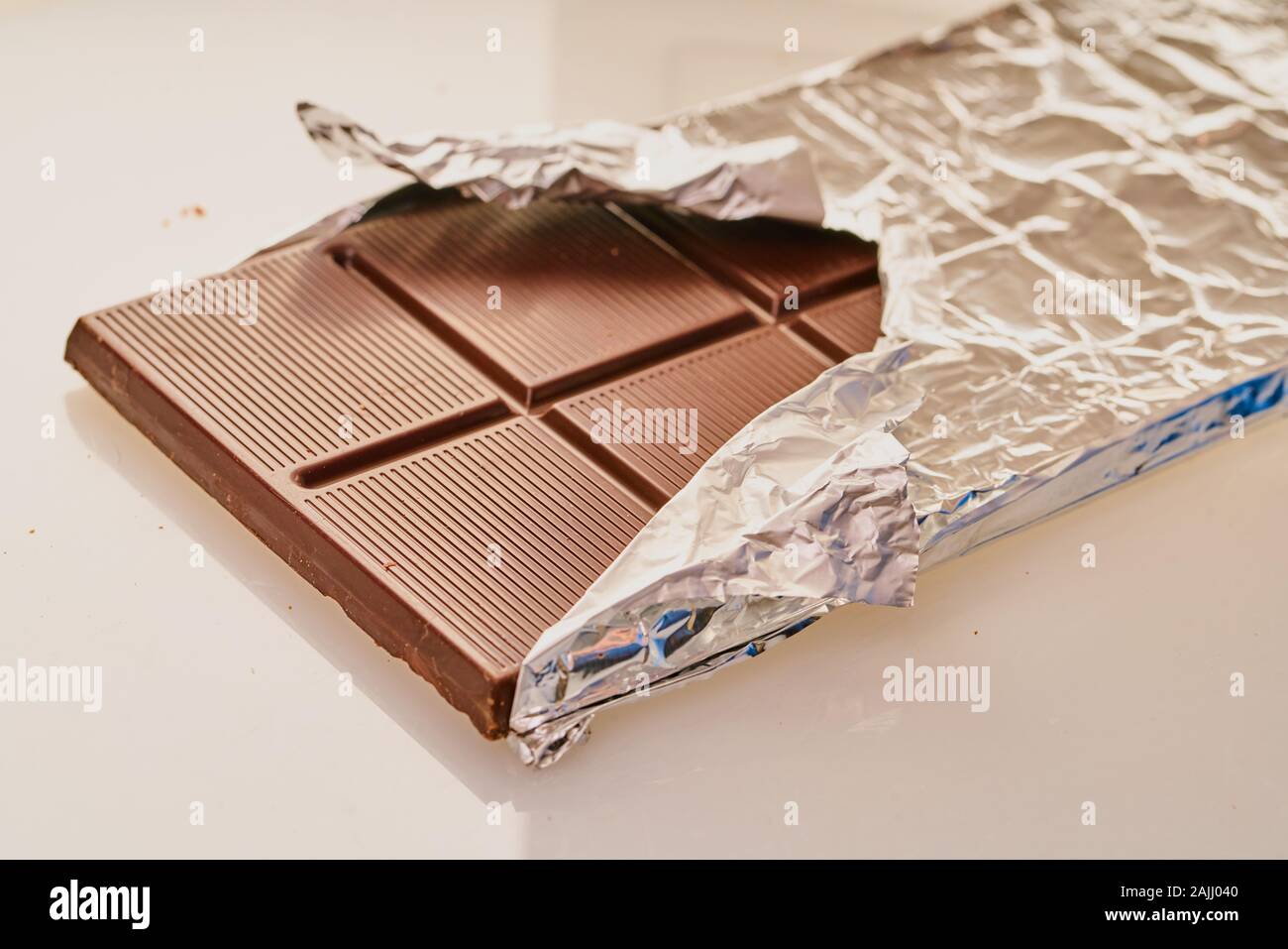 chocolate bar in foil on a white background Stock Photo - Alamy