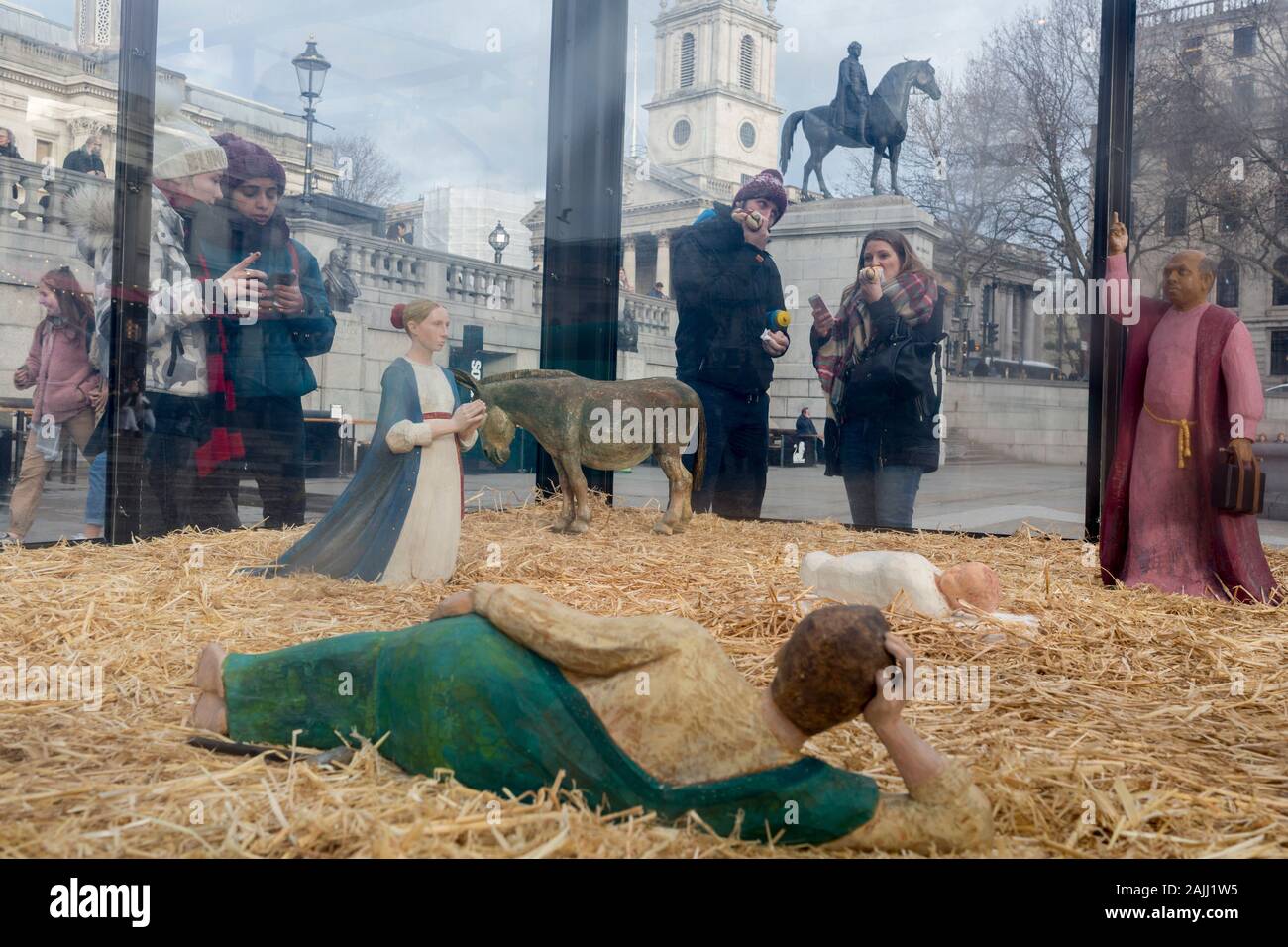 The annual Christmas nativity scene entitled 'Christmas Crib' by the artist Tomoaki Suzuki and located in Trafalgar Square, attracts interest from onlookers, on 13th December 2019, in London, England. Stock Photo