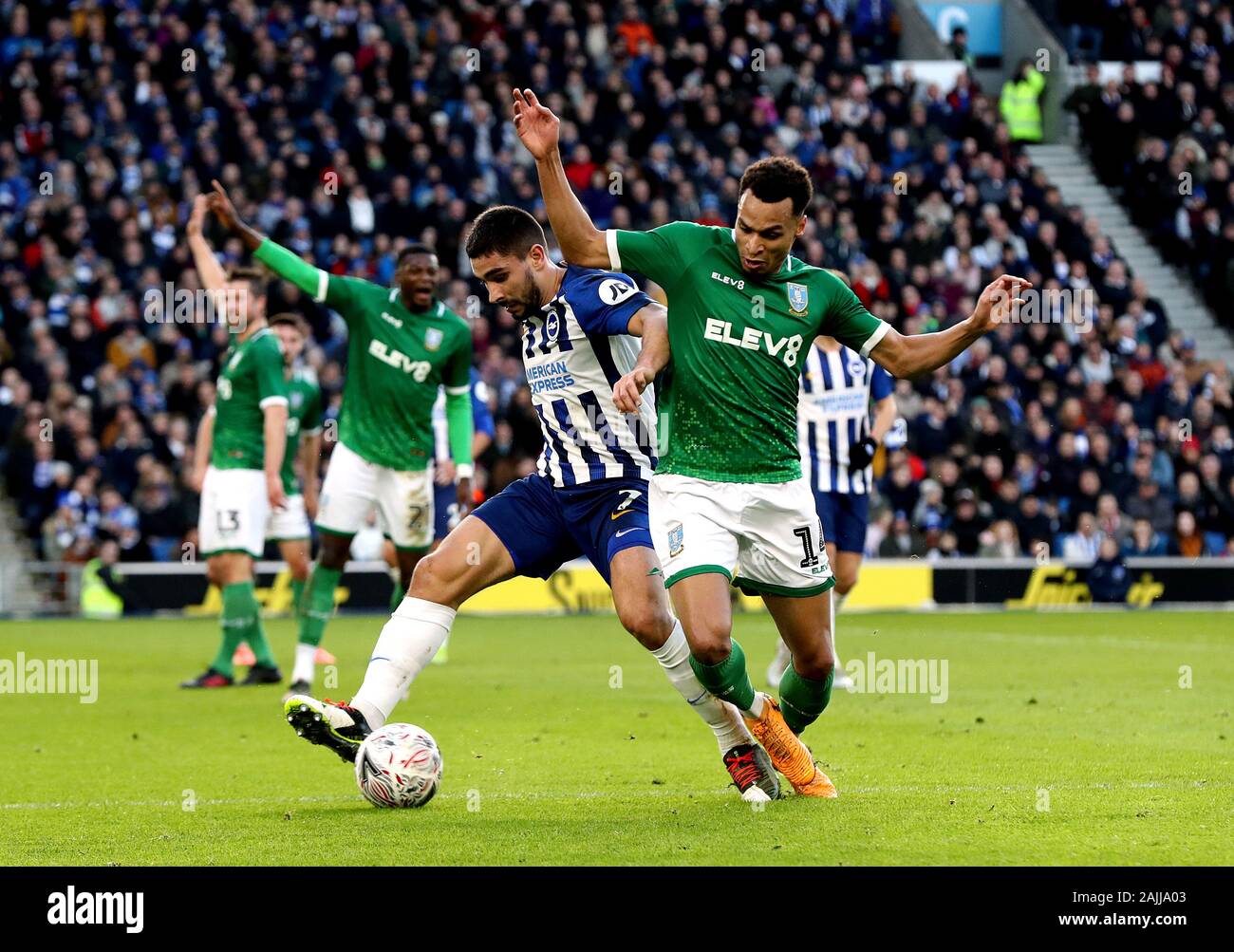 Brighton and Hove Albion's Neal Maupay (left) and Sheffield Wednesday's Jacob Murphy (right) battle for the ball during the FA Cup third round match at the AMEX Stadium, Brighton. Stock Photo