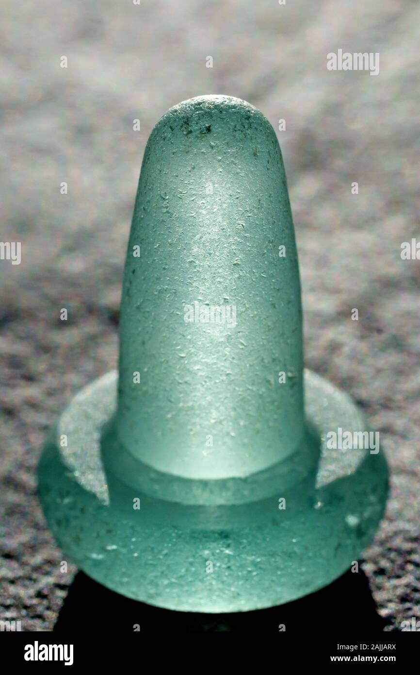 Close up still life of an old fashioned, pale green, backlit glass bottle stopper Stock Photo