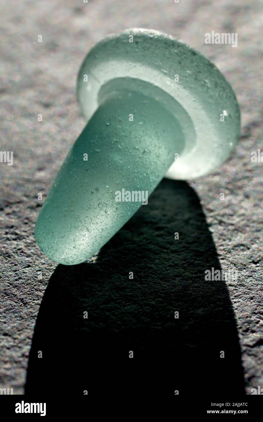 Close up still life of an old fashioned, pale green, backlit glass bottle stopper Stock Photo