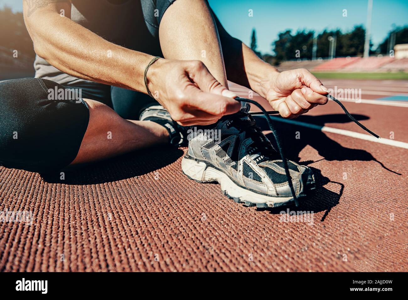 runner lacing shoes before work out on track Stock Photo