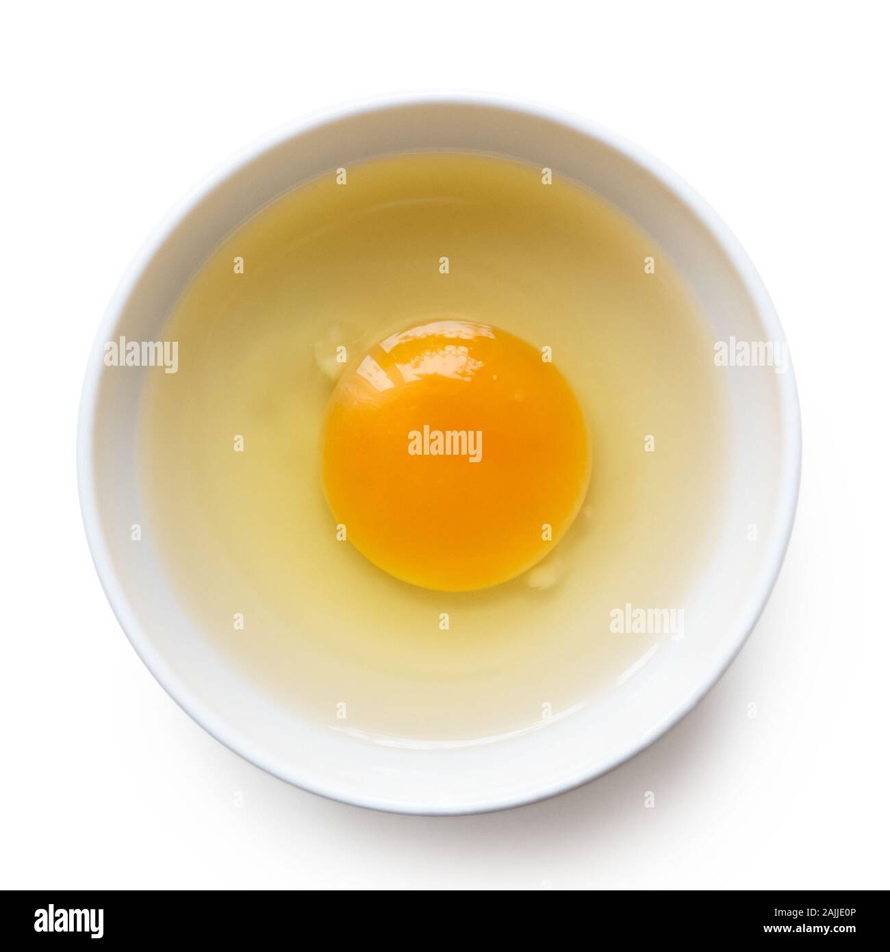 Broken egg in a white ceramic bowl isolated on white. Top view Stock