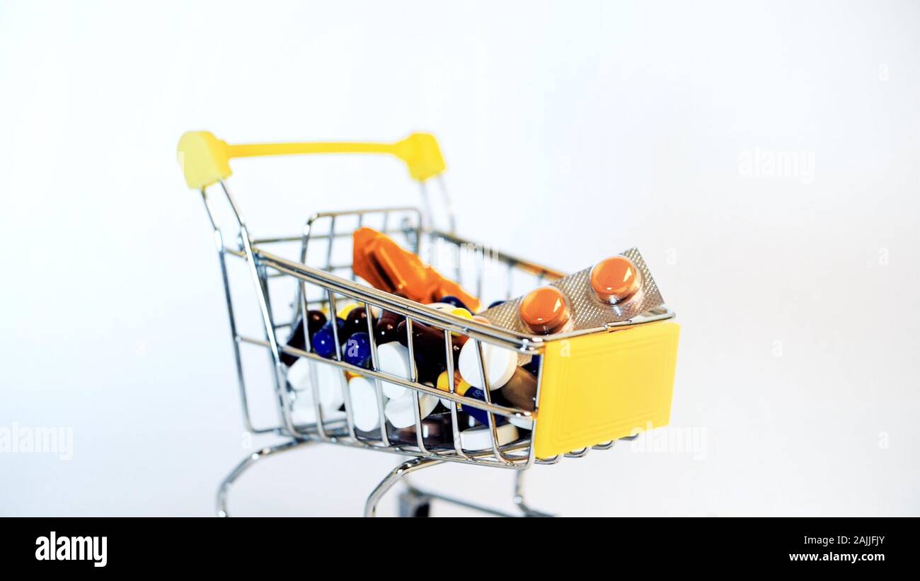 Supermarket trolley filled with medical capsules on a white background Stock Photo