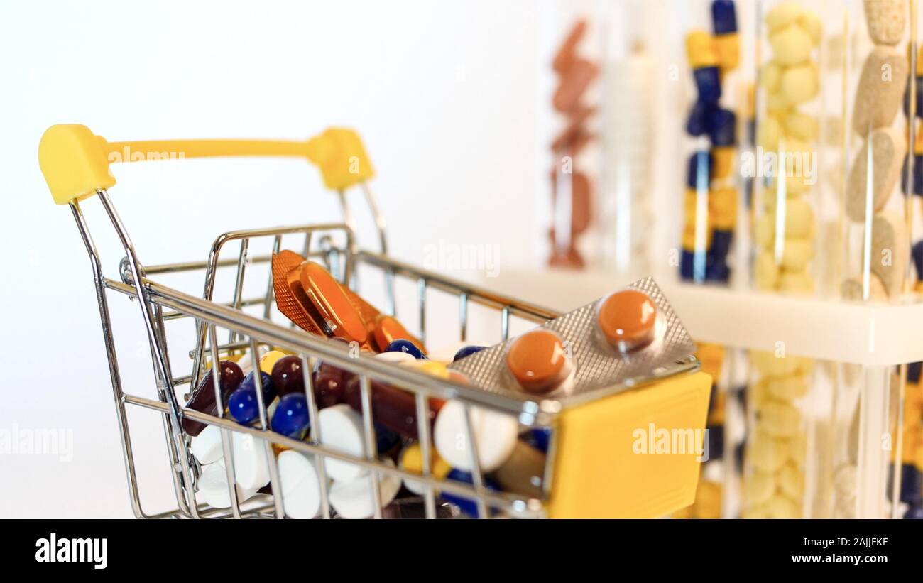 Supermarket trolley filled with medical capsules on a white background Stock Photo