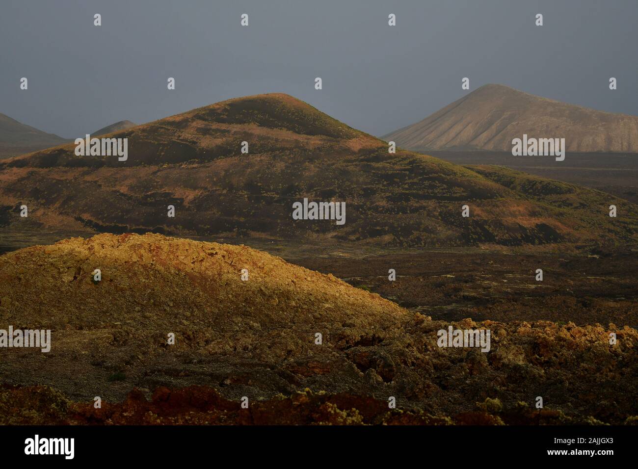 Beautiful volcanic landscape early in the morning in Lanzarote, Canary Islands, Spain. The calima wind makes a surreal light. Stock Photo