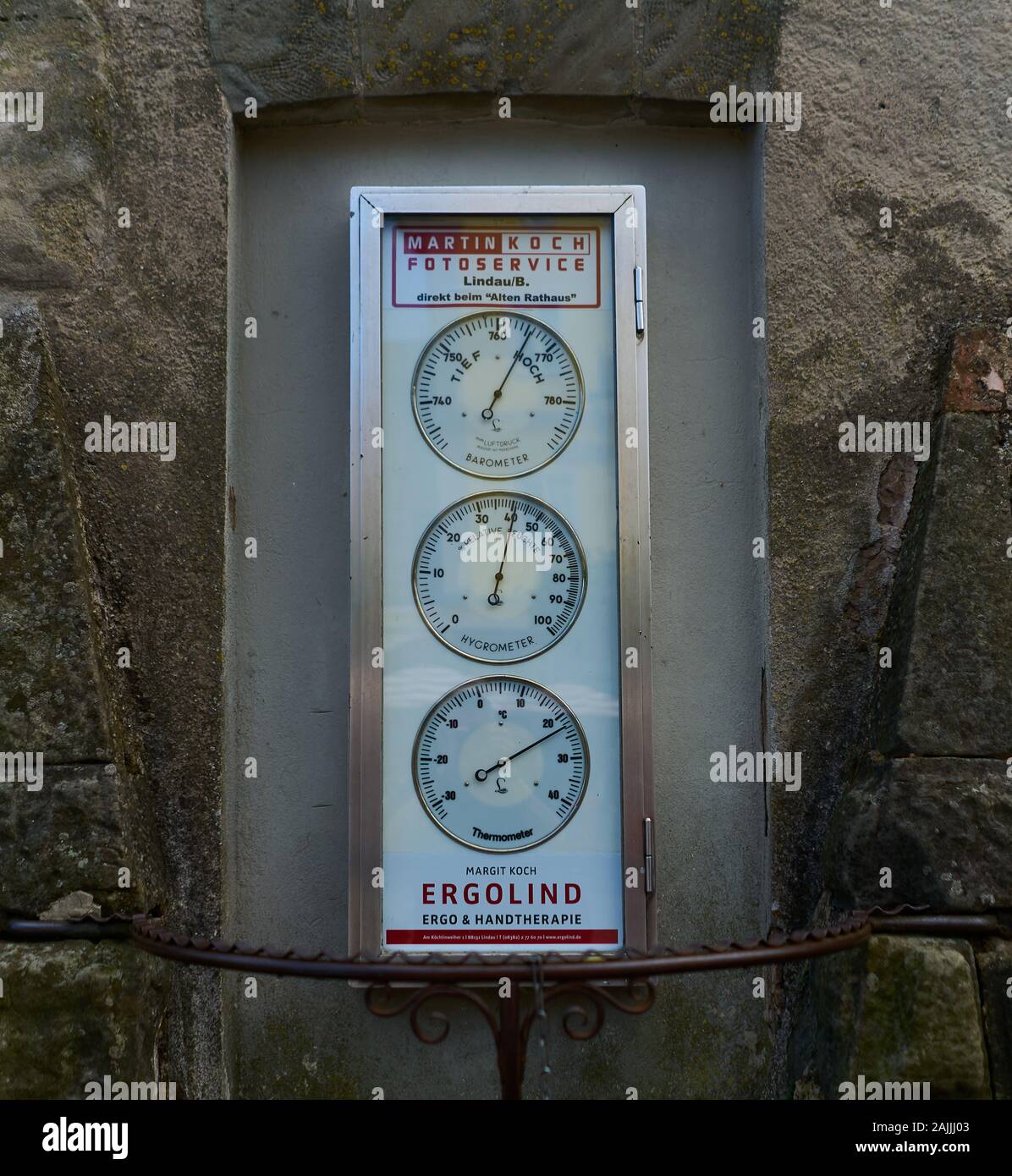 Old vintage weather multi-meter gauges set into carved out stone pilar in old medieval village in the German-Swiss border region. Stock Photo