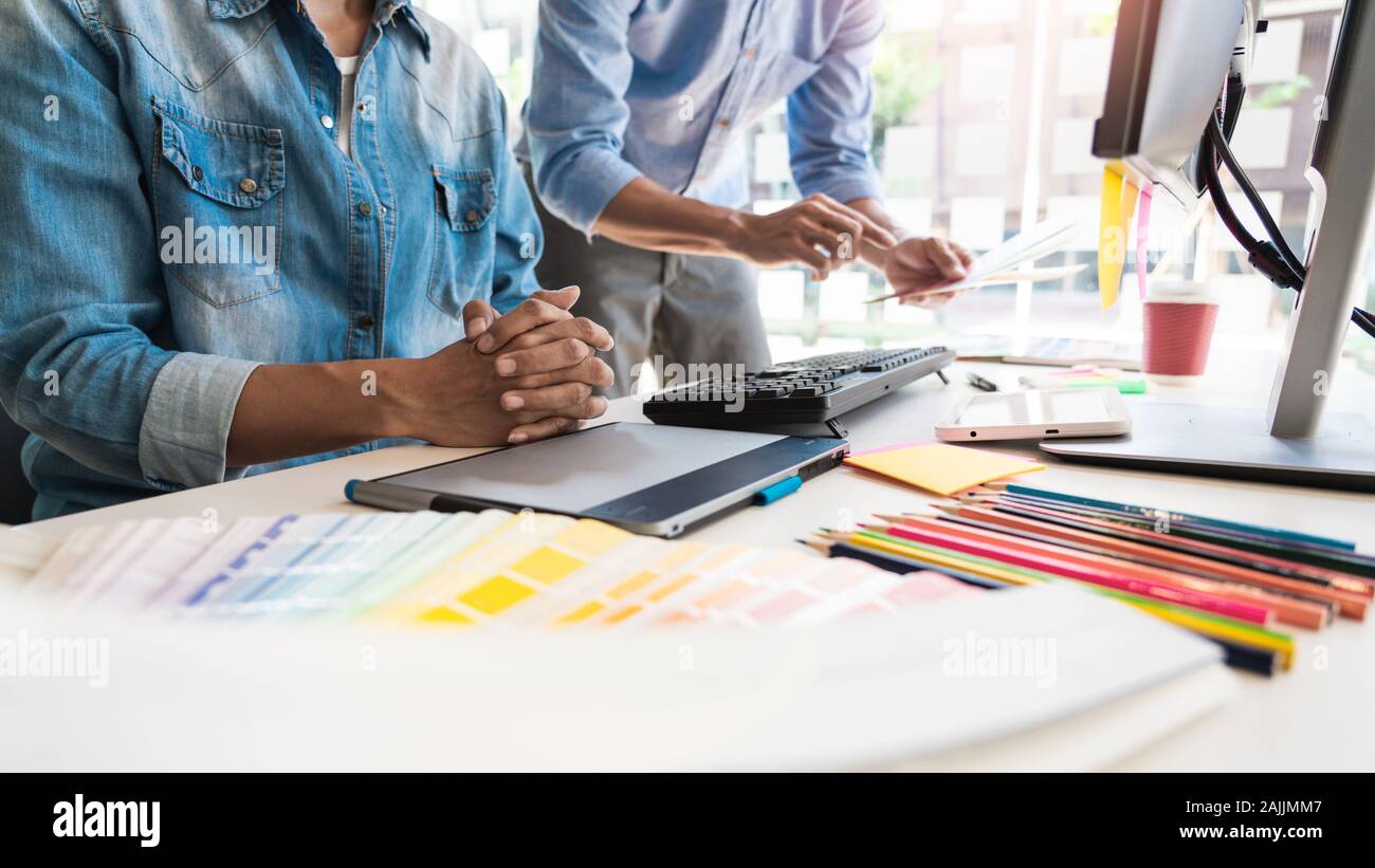 Professional Creative architect graphic desiner occupation choosing the Color pantone palette samples for project on office desktop computer. Stock Photo