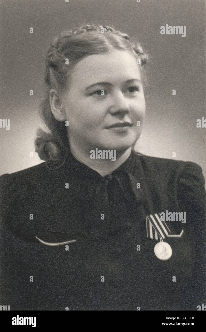 Vintage portrait of young woman with a medal ww2, Germany, 1946 Stock Photo
