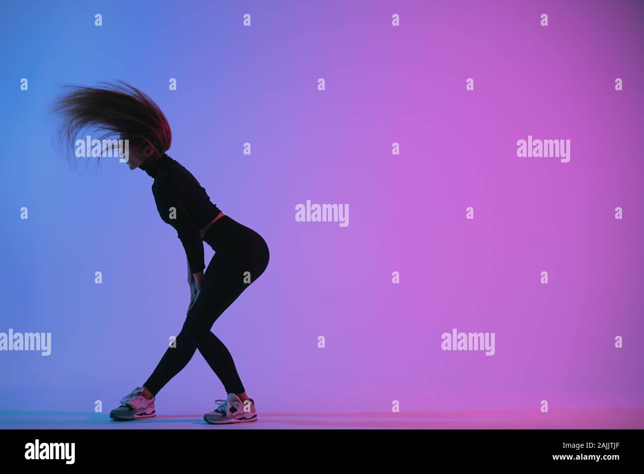 Sporty girl in charismatic jump moment against trendy color background.  Young fit dancer woman jumping. Studio shot Stock Photo - Alamy