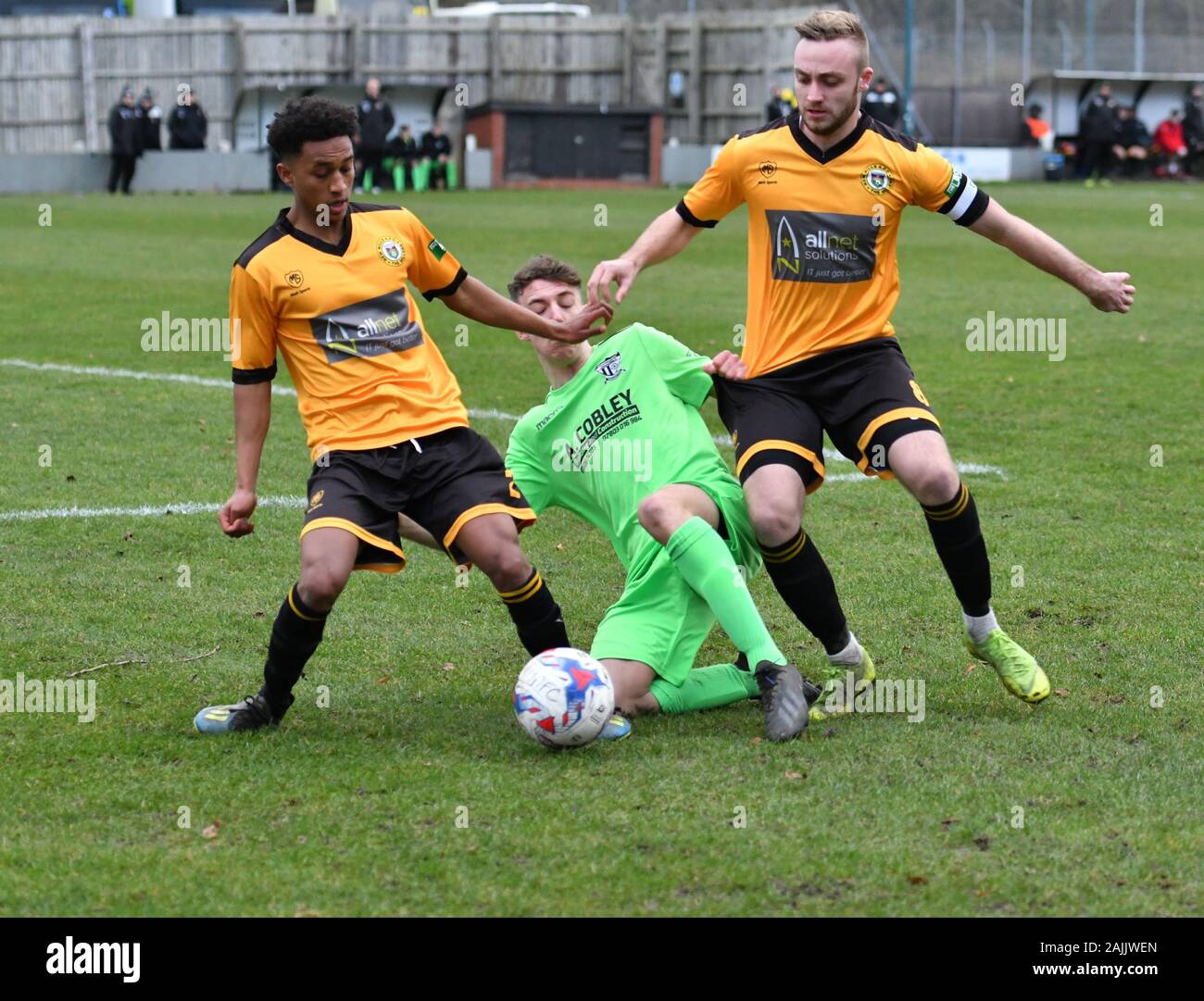 New Mills, Derbyshire. 4th January. 2020  Action from the North West Counties League match between New Mills (gold and black) and Barnton (green), New Mills win 1-0. Stock Photo