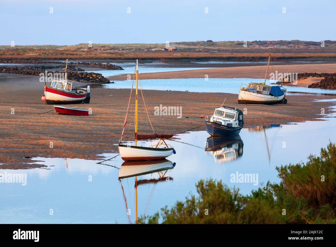 Boats on the River Burn sand at low tide at sunset, Burnham Overy Staithe, Norfolk, England, United Kingdom, Europe Stock Photo