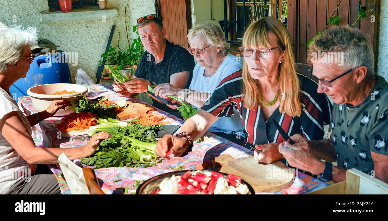 Family members preparing salads for celebration.  Provence France August Stock Photo