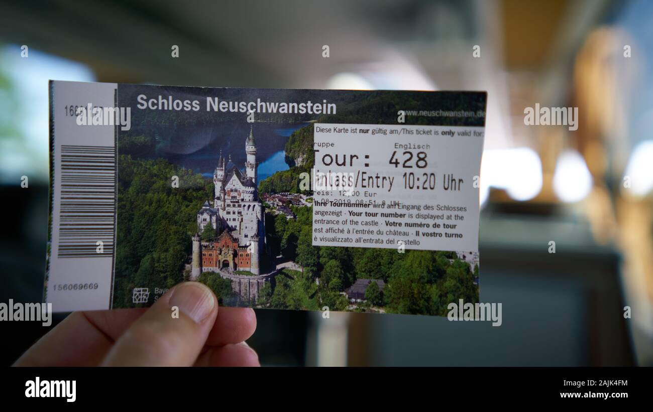 Close up of person holding an entry ticket to take a tour of the famous fairytale Neuschwanstein Castle, the model Disney used, built by King Ludwig. Stock Photo