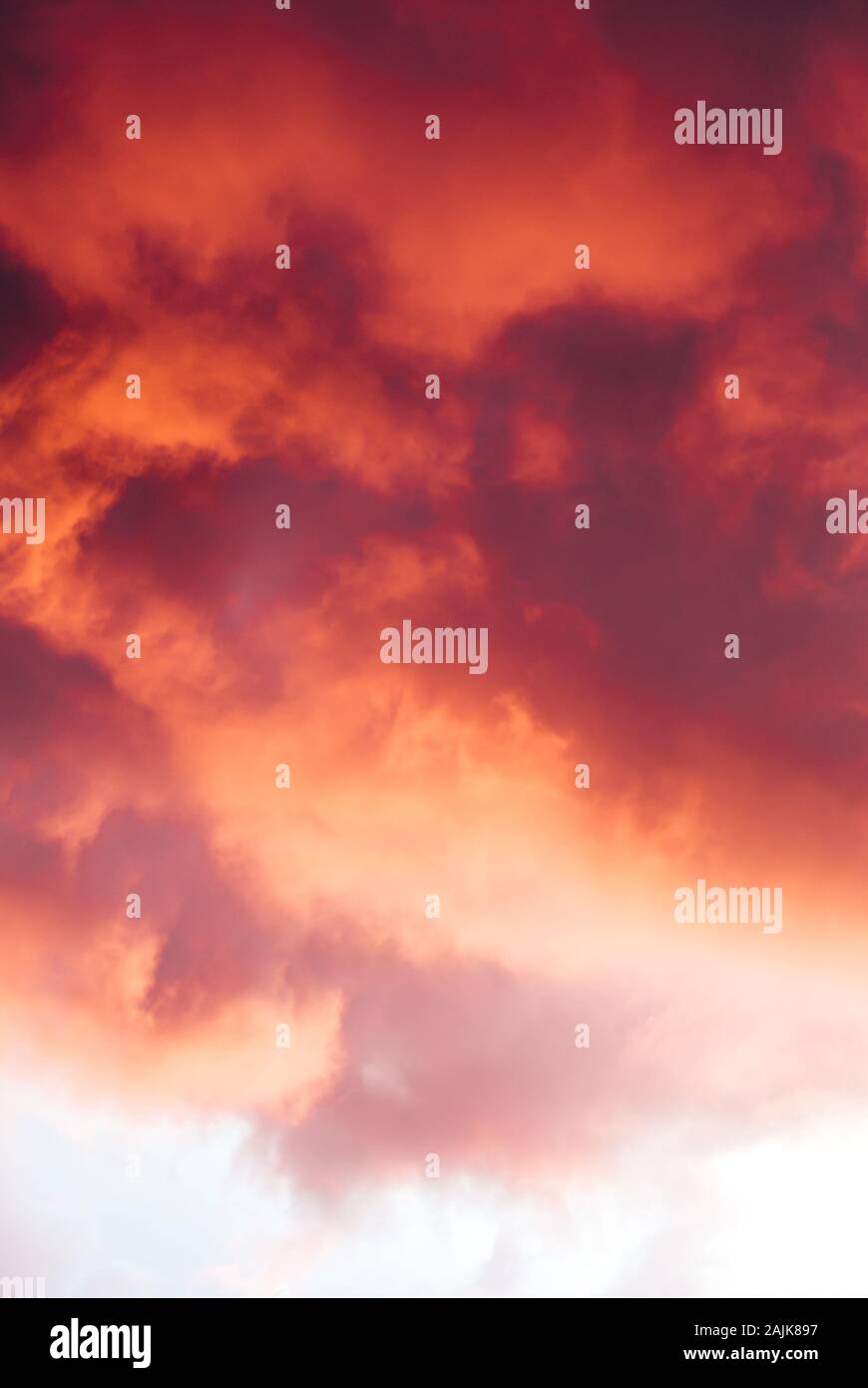 Storm clouds catching the red and orange glow of the sun Stock Photo