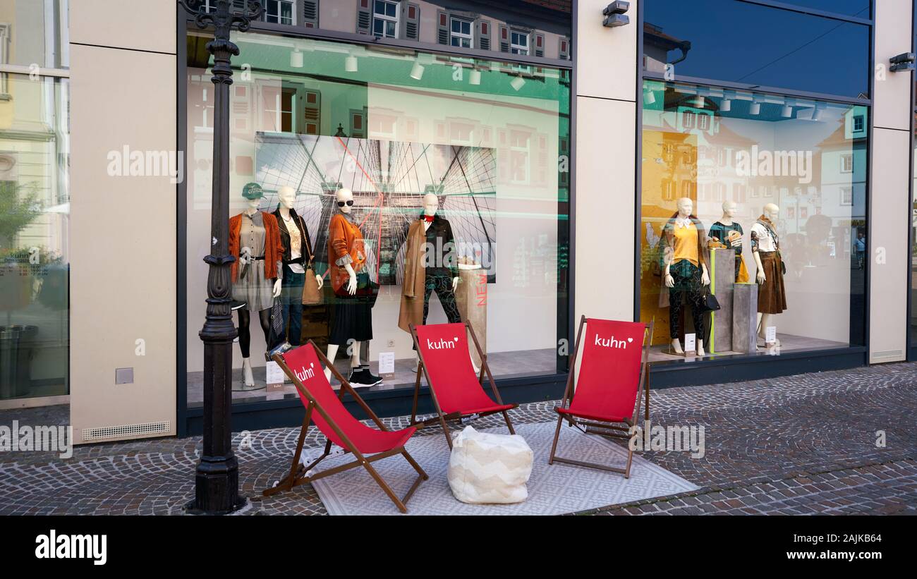 Red sling chairs set up outside clothing store featuring womens trendy  fashions in their window display in Bad Mergentheim, Germany Stock Photo -  Alamy