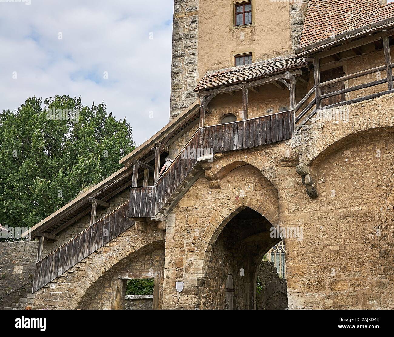 Woman climbs down stairs from the medieval fortification walls that surround the quaint village of Rothenburg ob der Tauber, Germany. Stock Photo