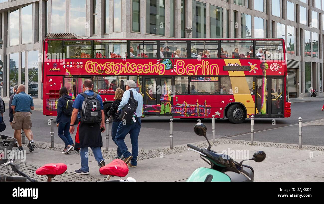 Colorful Hop on Hop Off Tour bus and pedestrians in this street scene in Berlin, near the Main Train Station. Stock Photo