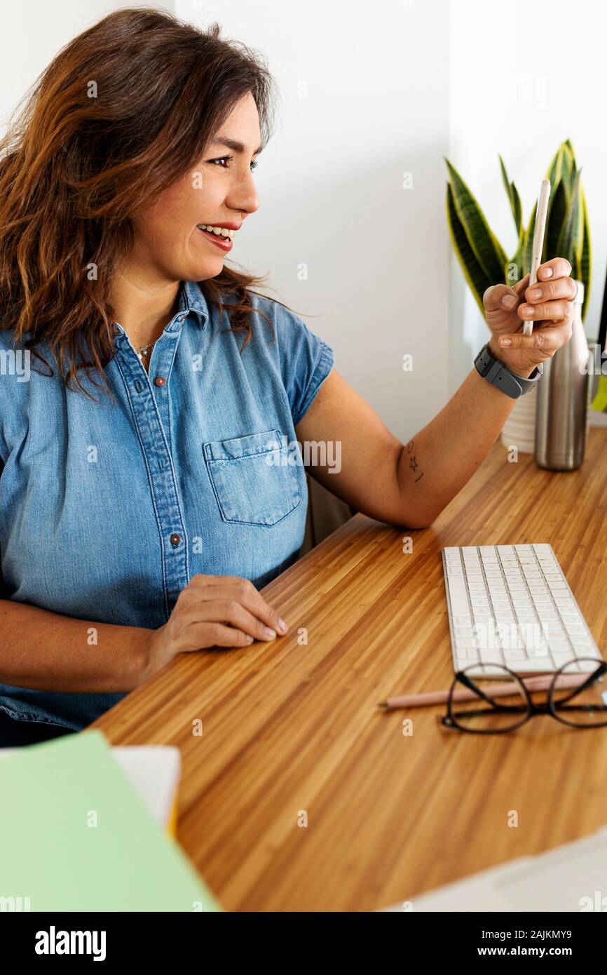 Smiley 40 years old woman making a video call Stock Photo