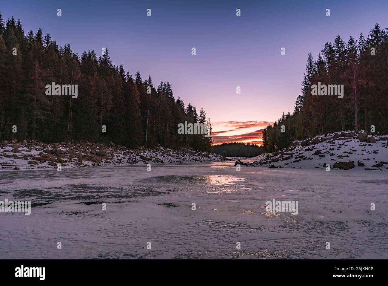 Winter nature. Snowy icy lake shore in mountains. Scenic winter landscape. Beautiful ice mountain lake Stock Photo