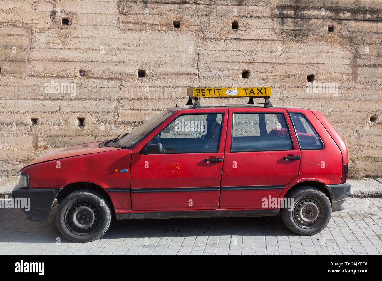 Red car with the yellow sign “PETIT TAXI”, Fes (Fez), Morocco Stock Photo