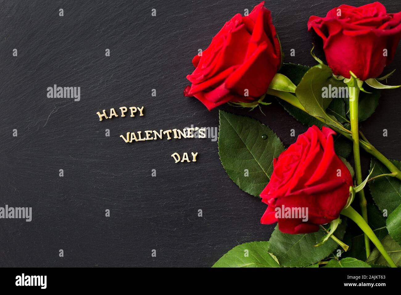 The inscription Happy Valentine and bright red roses Stock Photo - Alamy