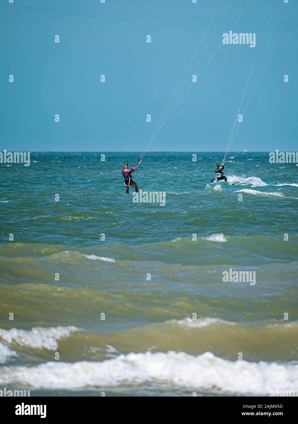 Two Kite Surfer from behind heading towards open seas Stock Photo