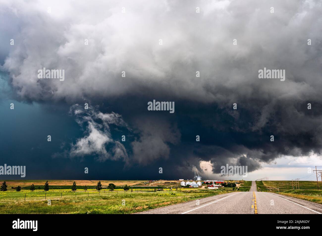 A stormy sky with dramatic, dark clouds sweeps across a farm as a severe thunderstorm approaches Anton, Colorado. Stock Photo