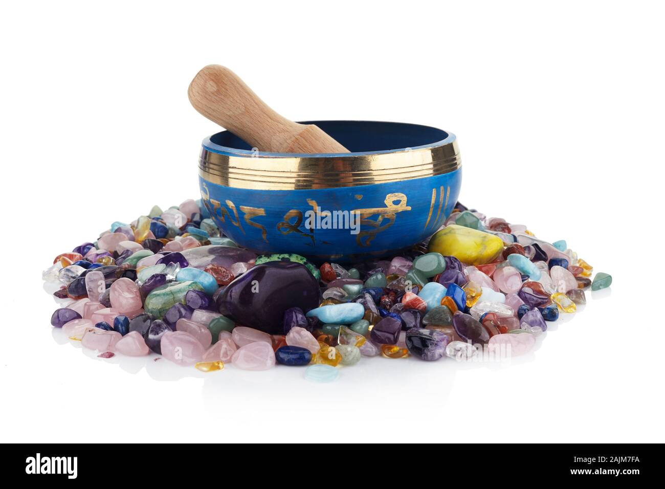 tibetan singing bowl and multicoloured healing stones against a white background Stock Photo