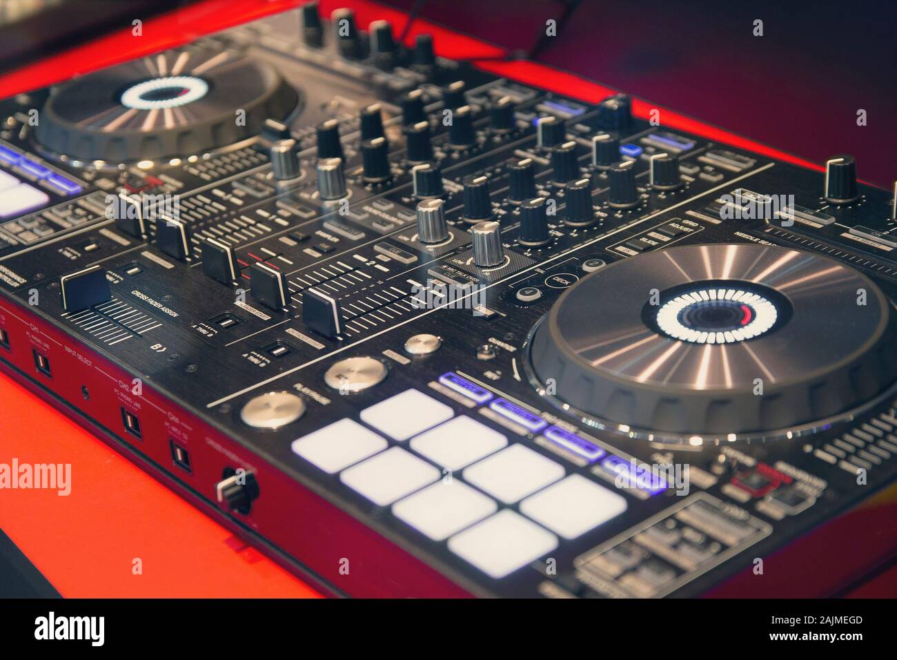 Disc Jockey mixing deck and turntables at night controls for mixing