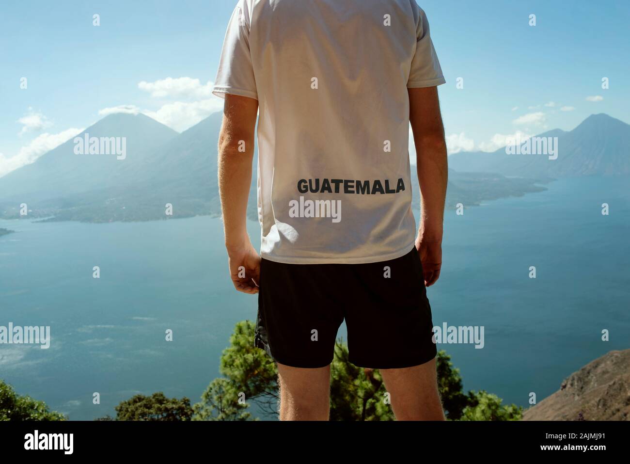 Tourist from behind looking at the scenic views of Lake Atitlán, Guatemala. Touristic / country promotion, travel lifestyle photo. Dec 2018 Stock Photo
