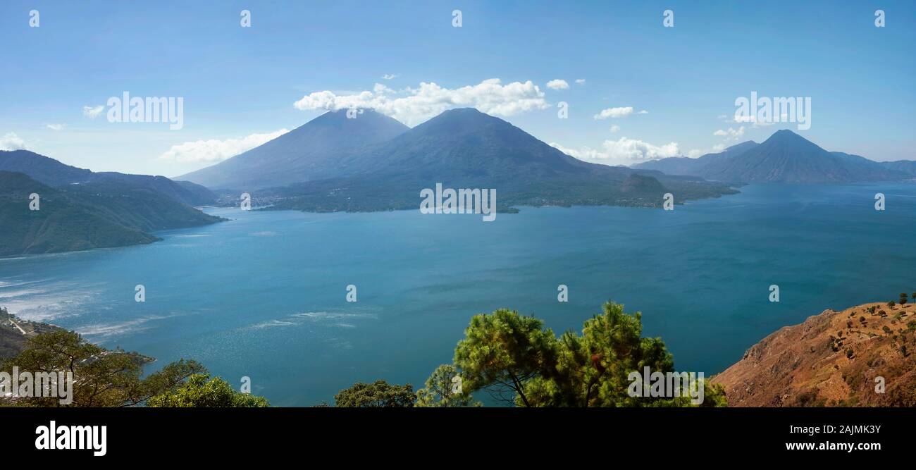 Panoramic shot of Lake Atitlán (formed in a massive volcanic crater) with surrounding volcanos and villages. Guatemala, Dec 2018 Stock Photo