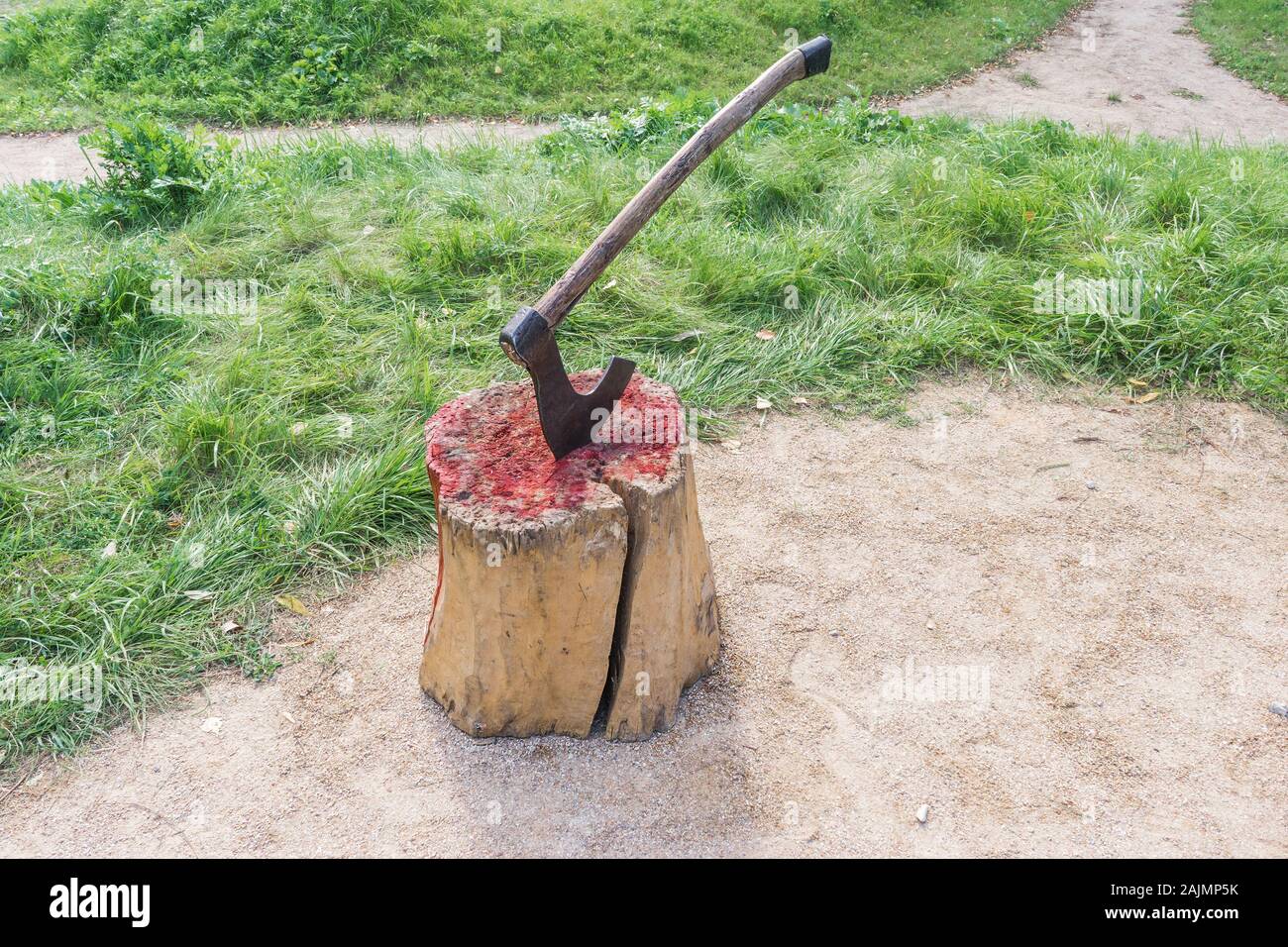 Axe of executioner from middle Ages. Beheading on medieval festival. Victim's blood on wooden stump. Bloody wood block at place of execution of defend Stock Photo