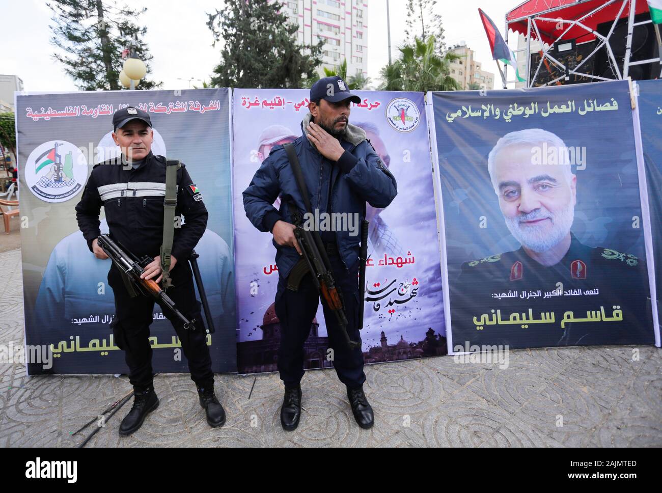 Palestinian Hamas policemen stand on guard next to the posters of Qassem Soleimani, the Iran's head of the Quds Force who was killed during the US air strike in Gaza City. Stock Photo
