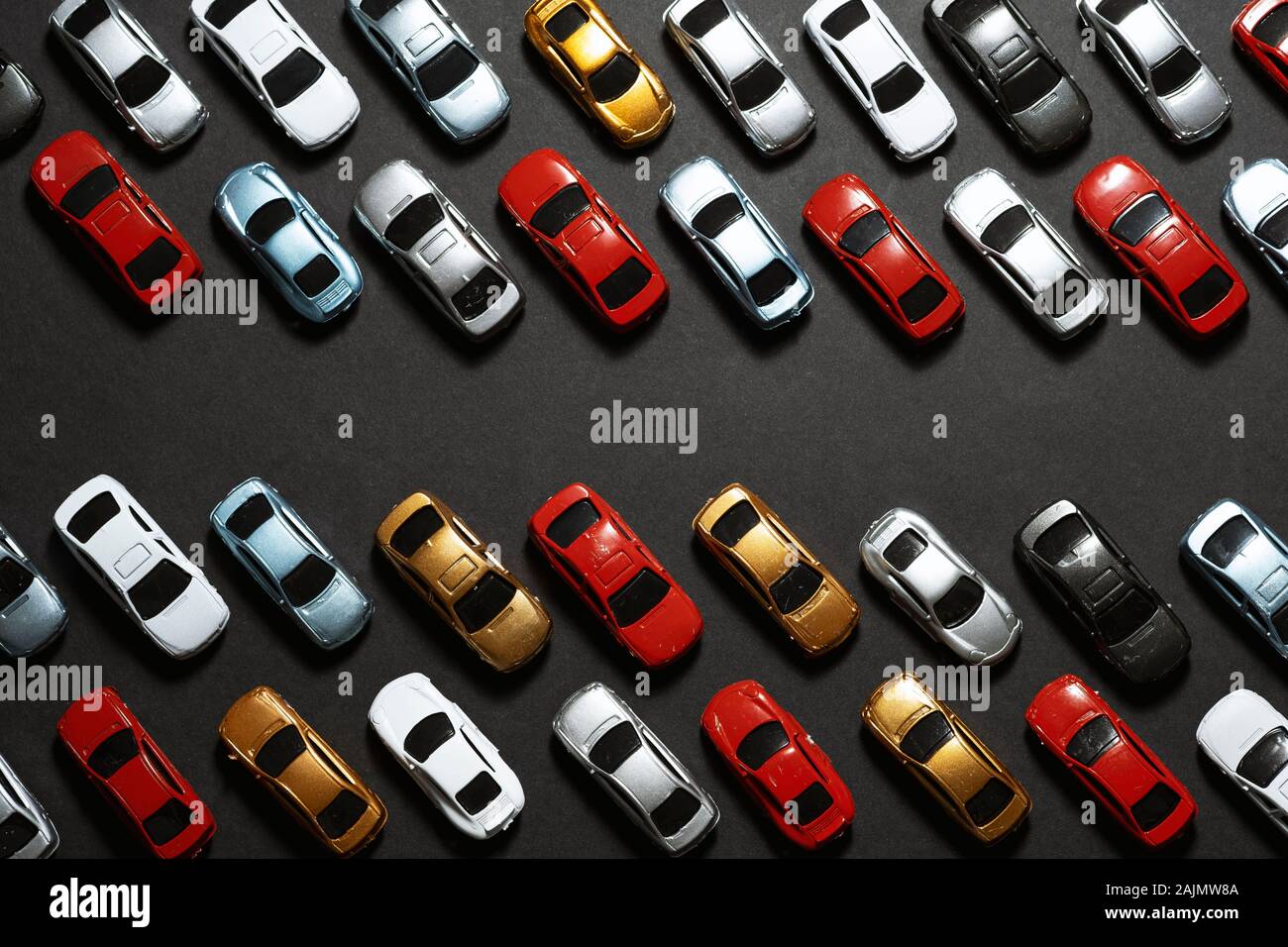 Top view of Parked toy cars on a black background like a car parking lot. Stock Photo
