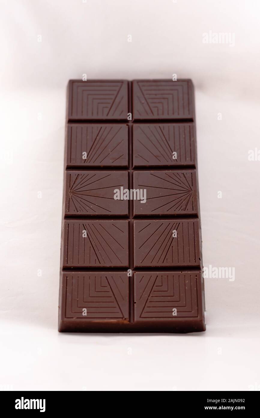Dark chocolate with whole hazelnuts isolated on white background Stock Photo