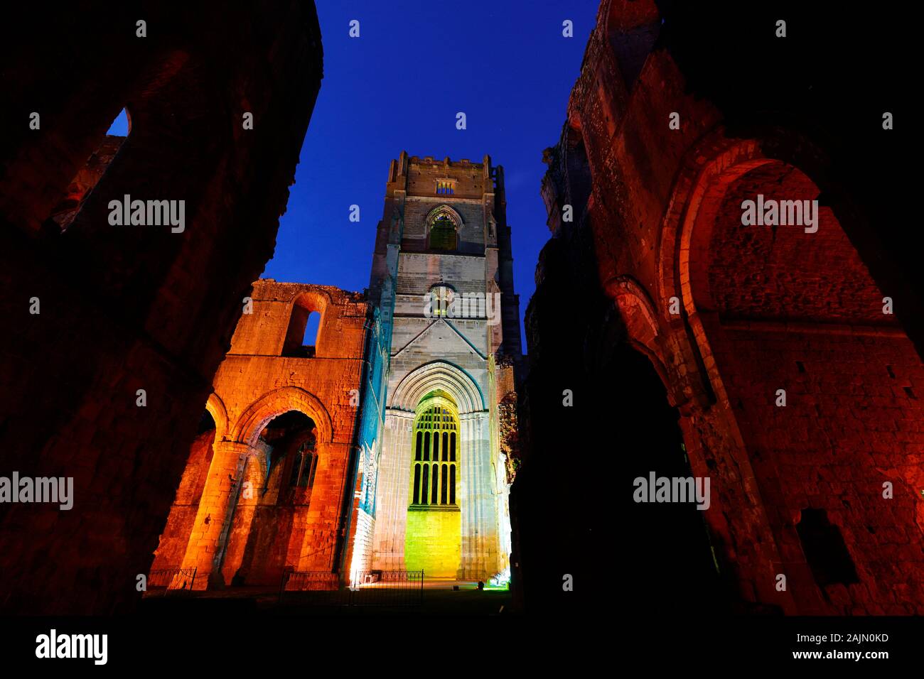 Fountains Abbey Tower at night, during Christmas coloured illuminations Stock Photo