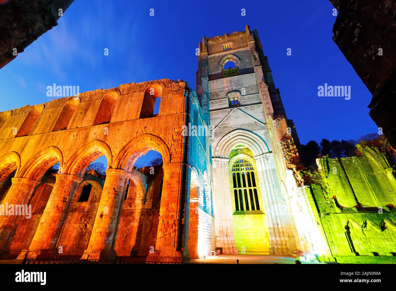 Fountains Abbey Tower at night, during Christmas coloured illuminations Stock Photo