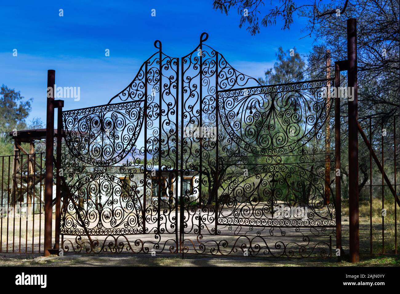 Ornate scroll work in wrought irons gates at entrance to an adobe home in the artisan town of Tubac, AZ, USA Stock Photo