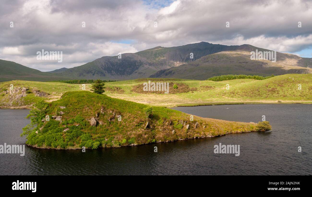 Snowdon mountain rises from the shores of Llyn y Dywarchen, a small lake ar Rhyd-Ddu in Snowdonia National Park, North Wales. Stock Photo