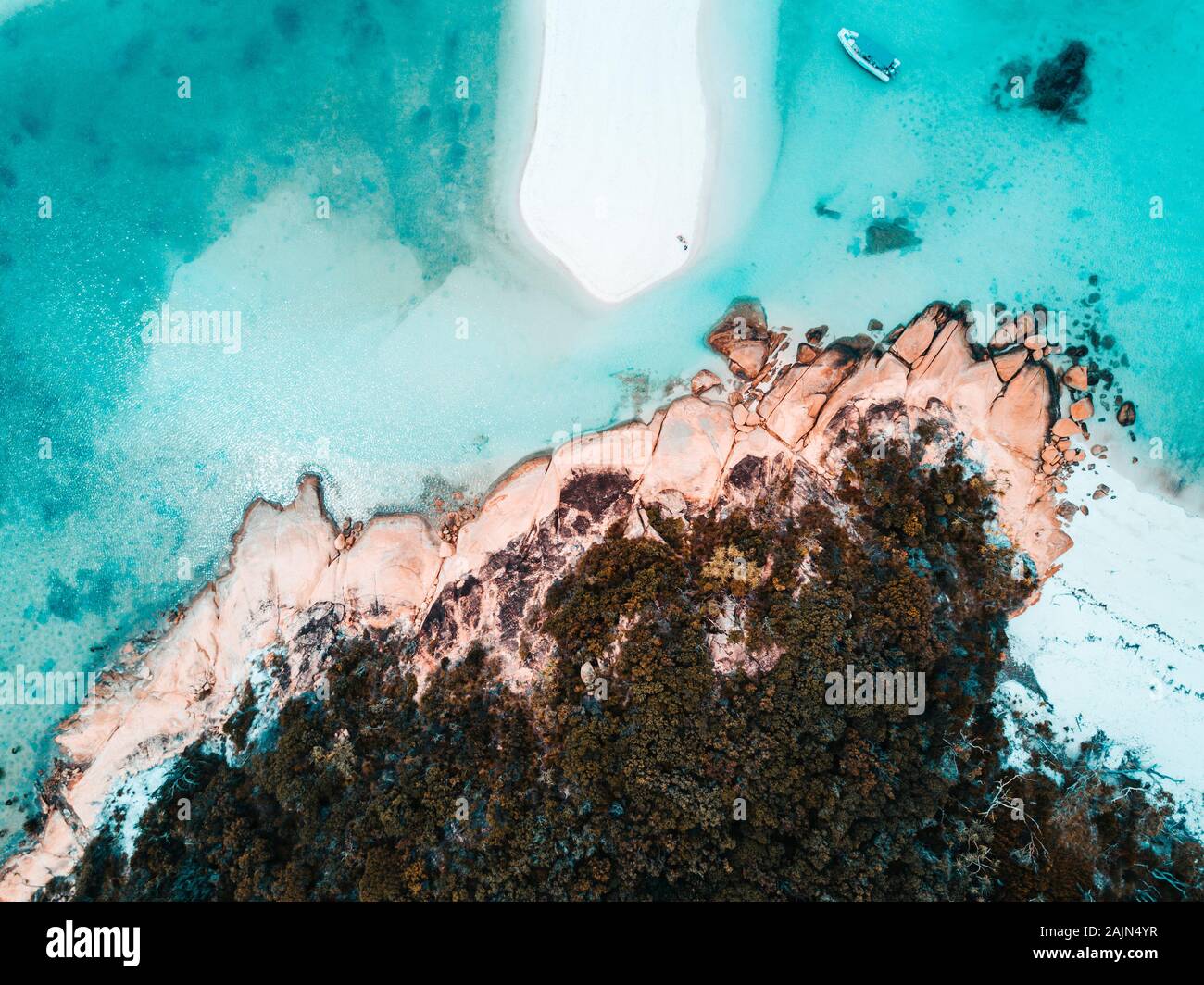 Aerial of a sand island next to rocky beach Stock Photo