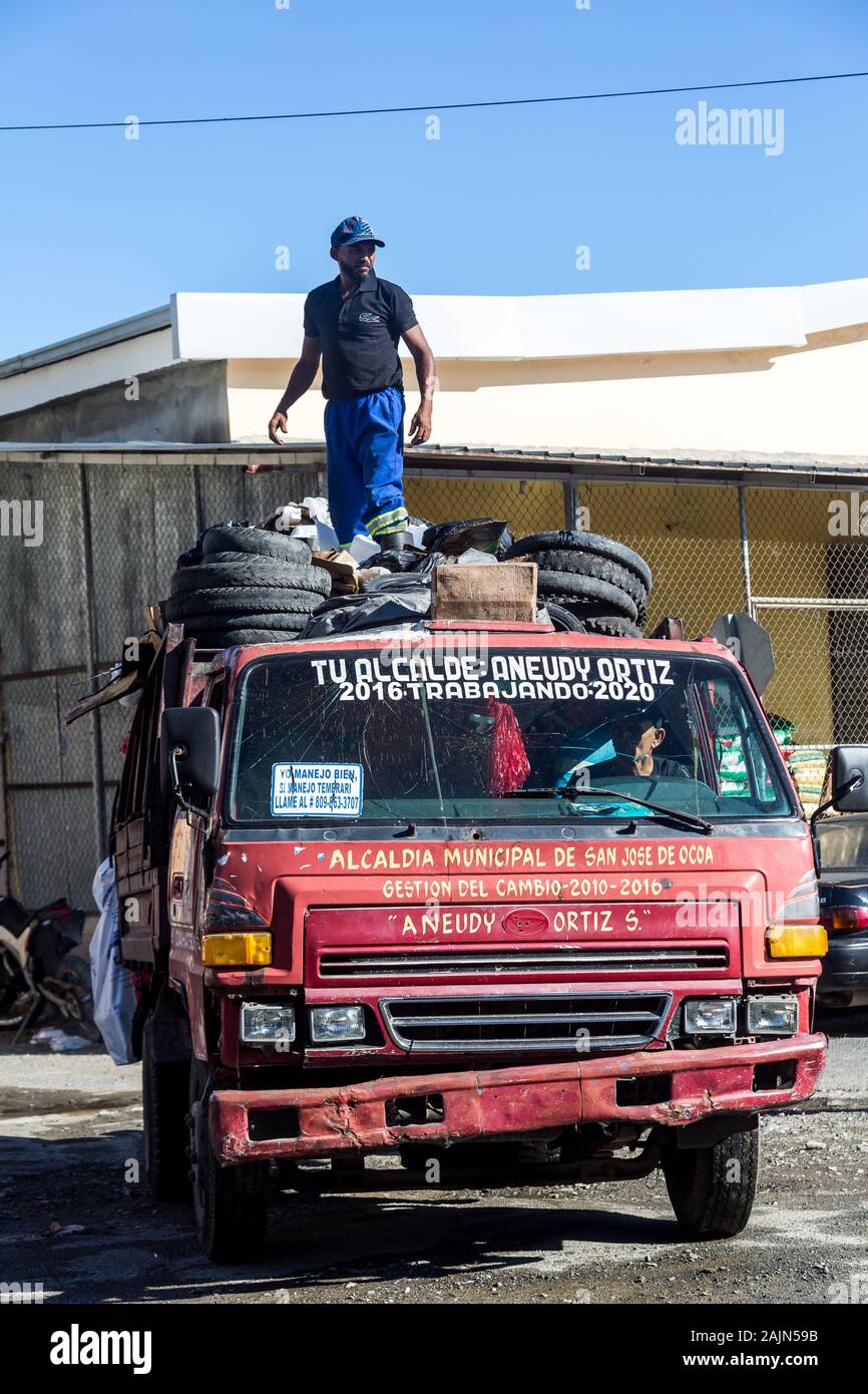 dramatic image of garbage workers on a garbage truck dumping trash cans
