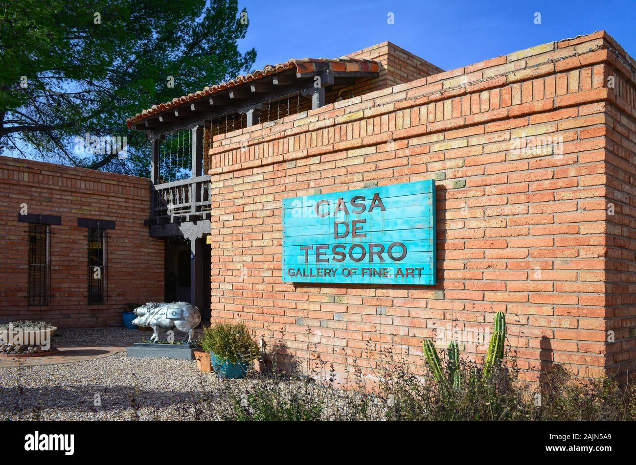 Southwestern adobe building houses Casa de Tesoro, Gallery of fine Art, with Javalina sculpture at entrance and turquoise sign Stock Photo