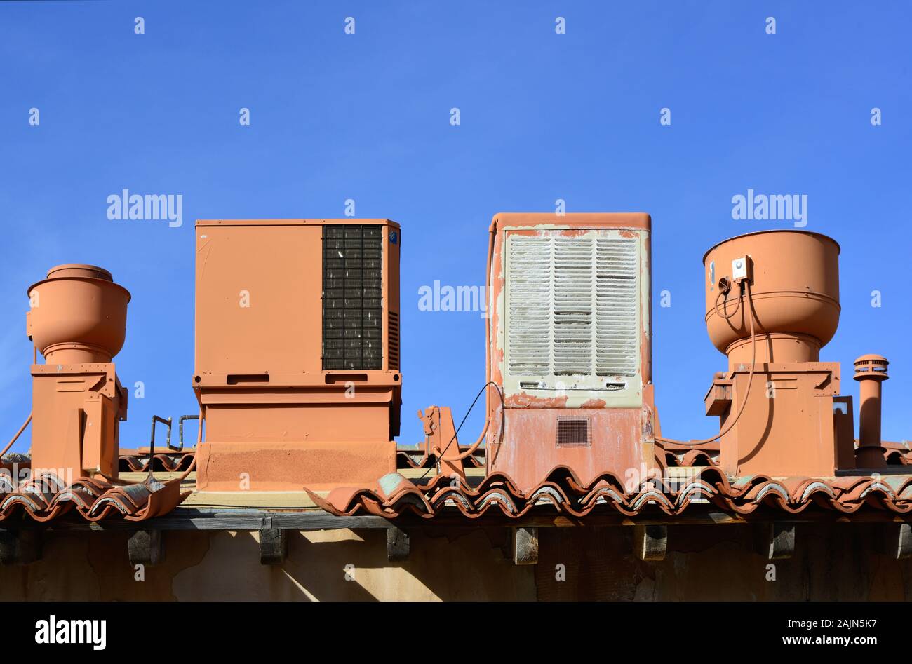 Spanish tile rooftop with old swamp cooler, air conditioner, vents and