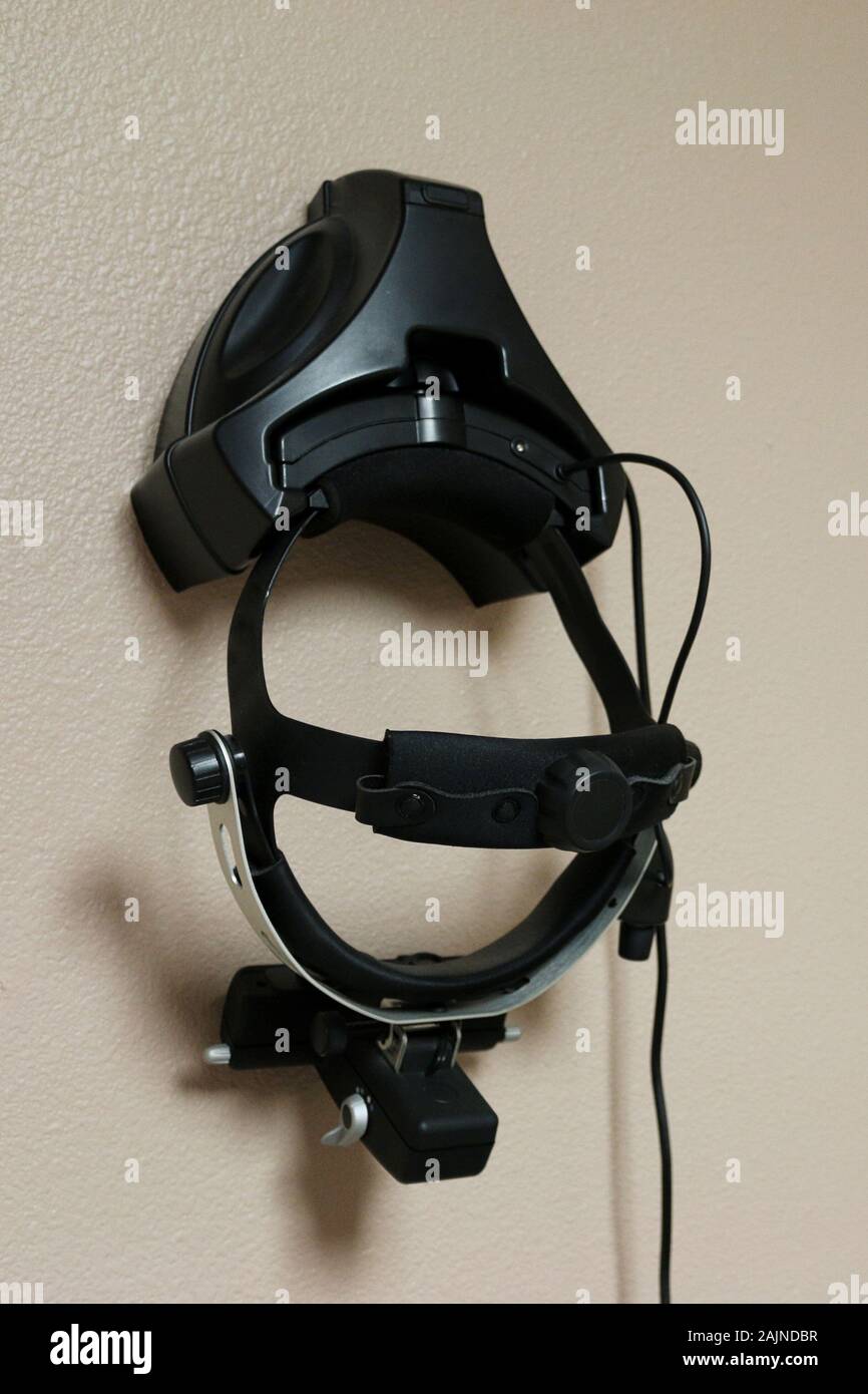BIO binocular direct ophthalmoscope hanging on wall in optometry eye exam room used for retinal examinations of the internal ocular structures Stock Photo