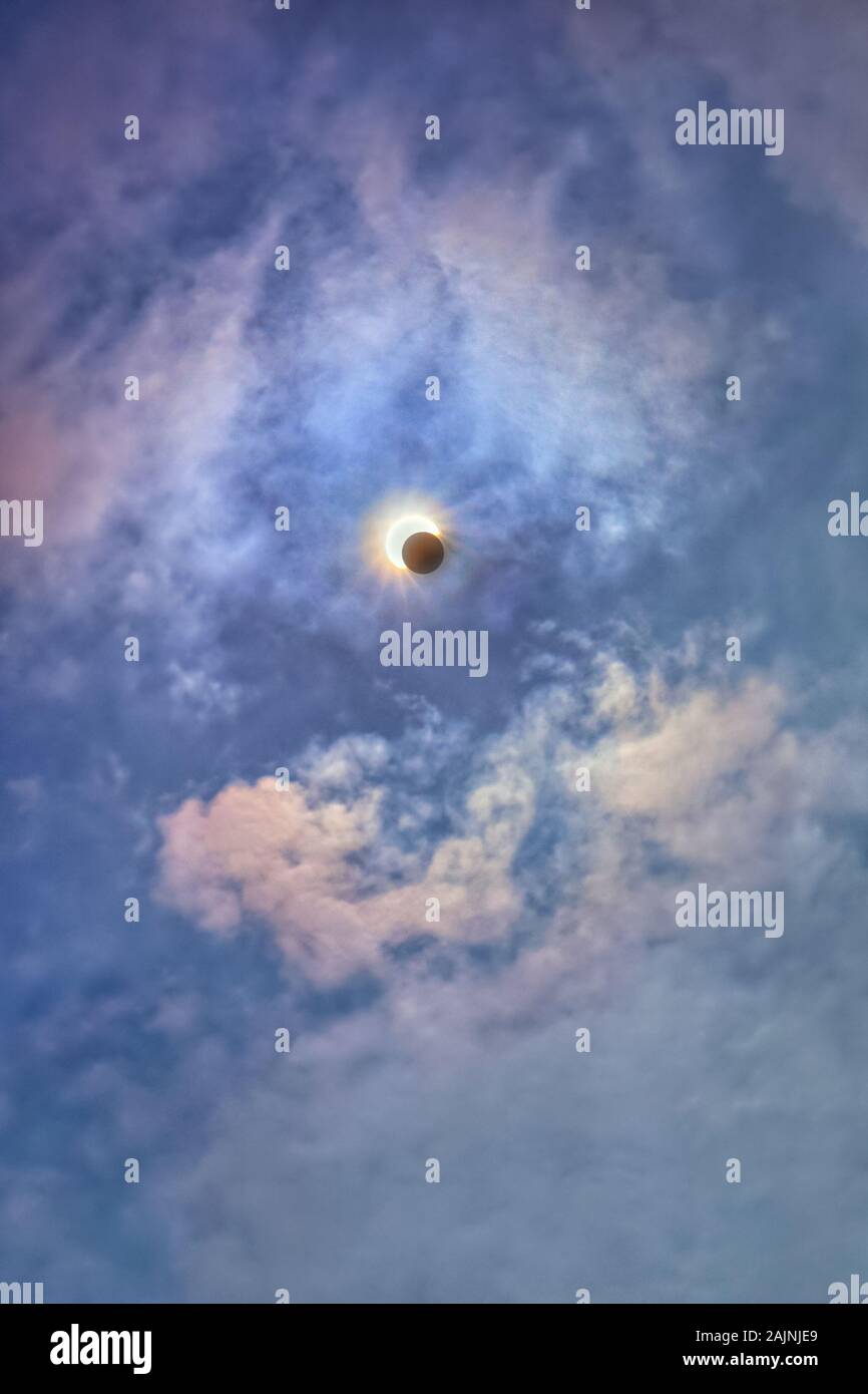 Bright blue sky with clouds and a solar eclipse. A shadow half closed ...