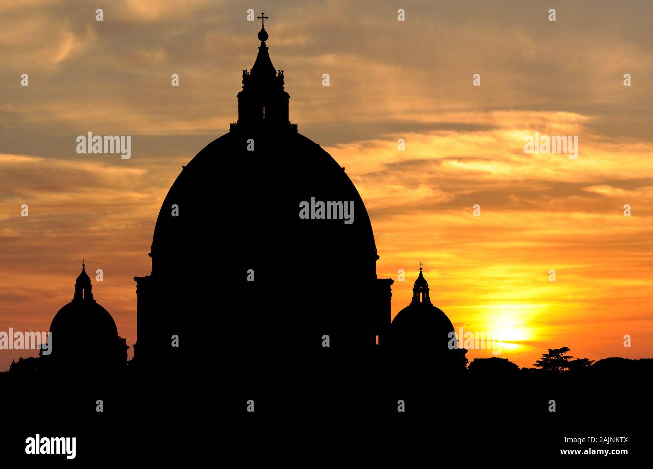 Silhouette of the huge domes of Saint Peters Basilica breaking the skyline at sunset in Vatican City, Rome Stock Photo