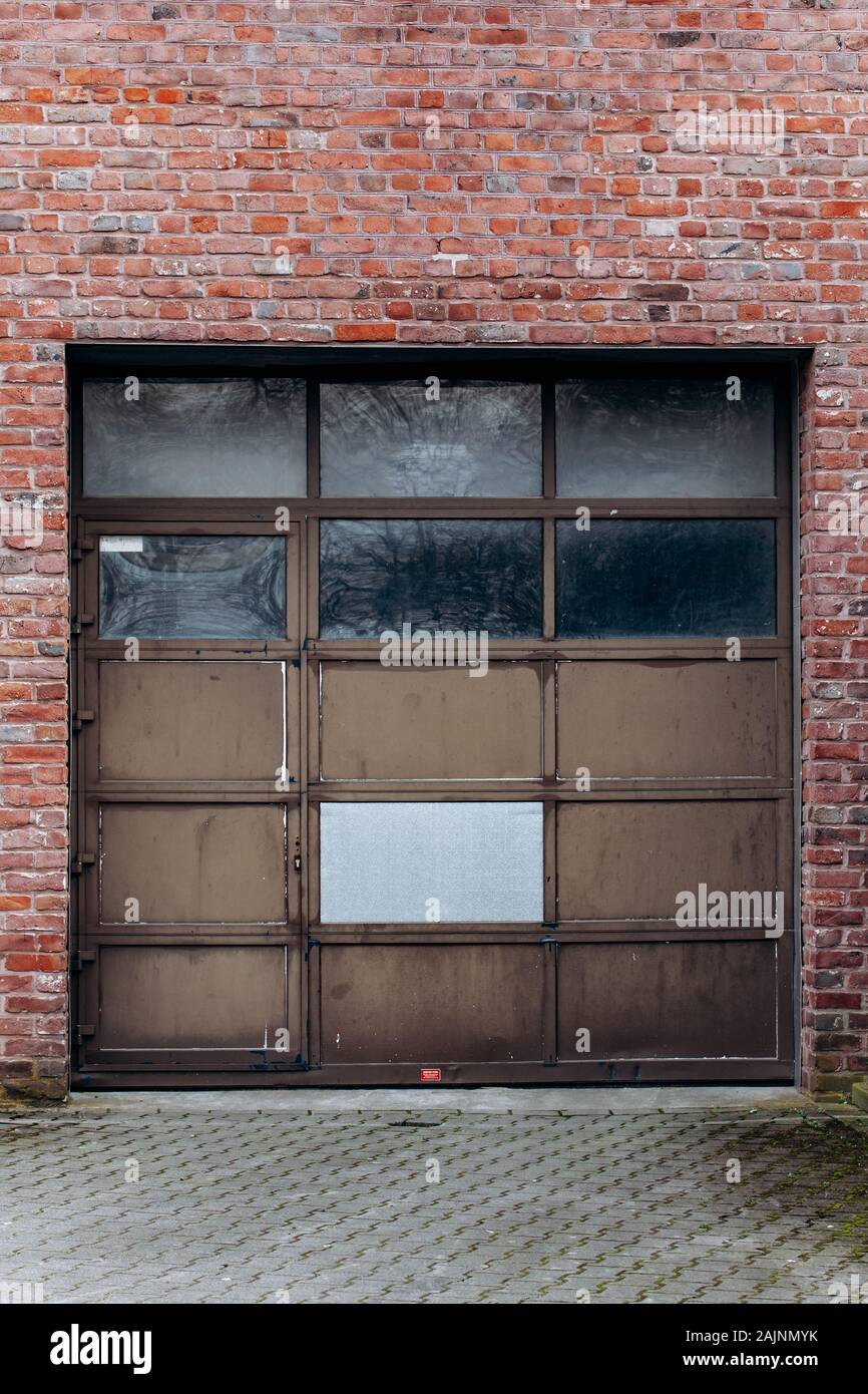Large garage door with brick wall and asphalt driveway Stock Photo Alamy