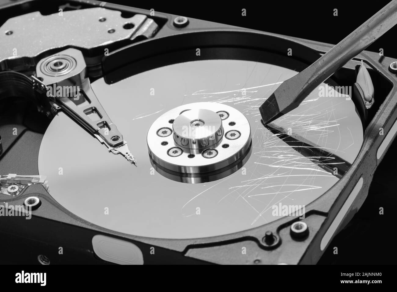 Screwdriver destroying a hard disk drive platter to erase the data Stock Photo