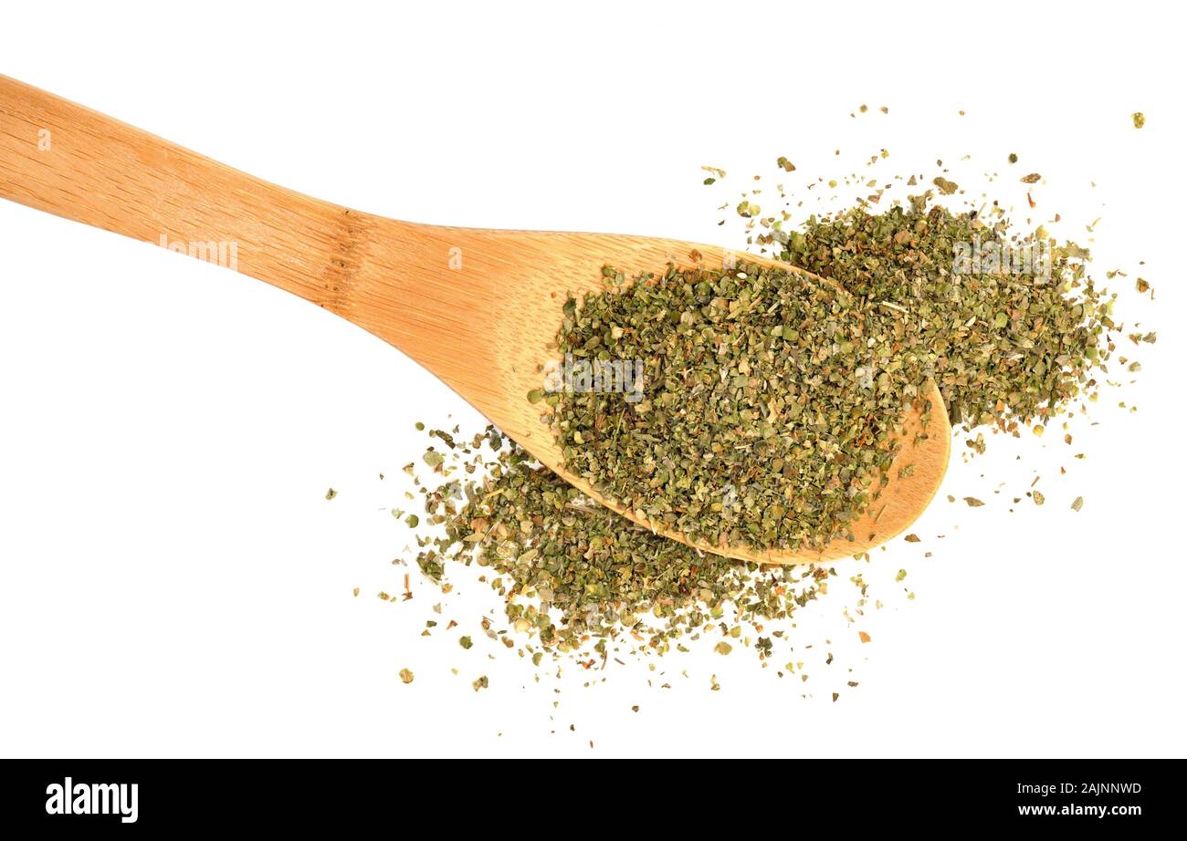 Overflowing spoonful of dried marjoram leaves on a white background Stock Photo